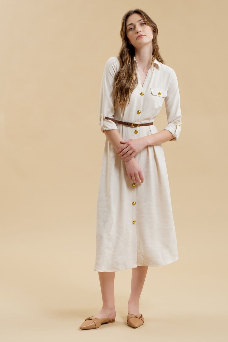 Get ready to stand out in the Monica Midi Dress, featuring a collared neckline and button down front. With gold buttons and hardware, this dress comes complete with a belted waist and pintuck details for a flattering silhouette. The long sleeves with cuff and tab detail, along with the midi length, make this a versatile shirt dress for any occasion. Plus, it even has pockets for added convenience! Elegant Belted Dress With Spread Collar, Chic Collared Dress With Belt, Elegant Collared Belted Dress With Button Closure, Elegant Belted Midi Dress With Button Closure, Midi Length Belted Dress With Buttons For Workwear, Chic Beige Belted Dress For Work, Long Sleeve Dresses With Belt For Daywear, Belted Dress With Spread Collar For Fall, Collared Dresses With Belted Cuffs For Fall