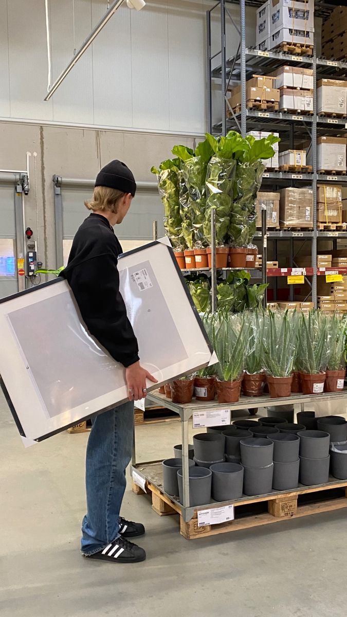 a man holding a large box with plants in it