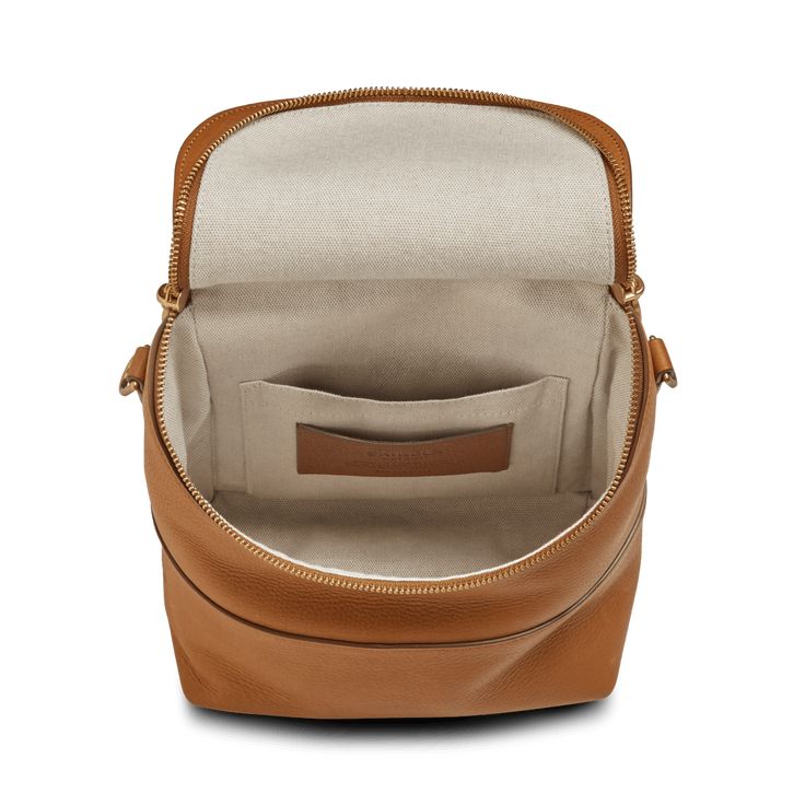 the inside of a tan leather purse on a white background with an open zippered compartment