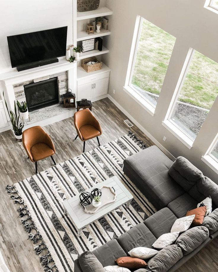 an overhead view of a living room with couches, chairs and a television on the wall