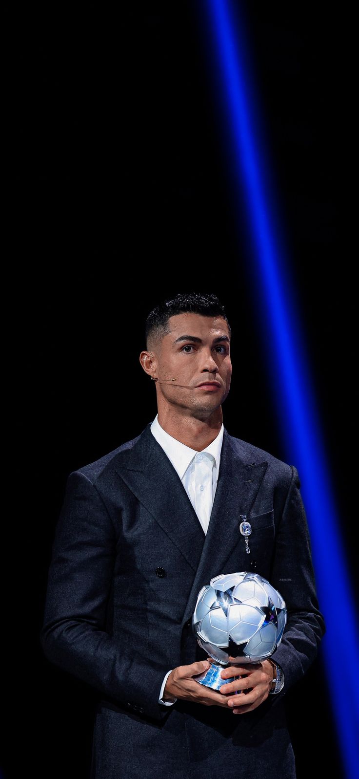 a man in a suit holding a soccer ball