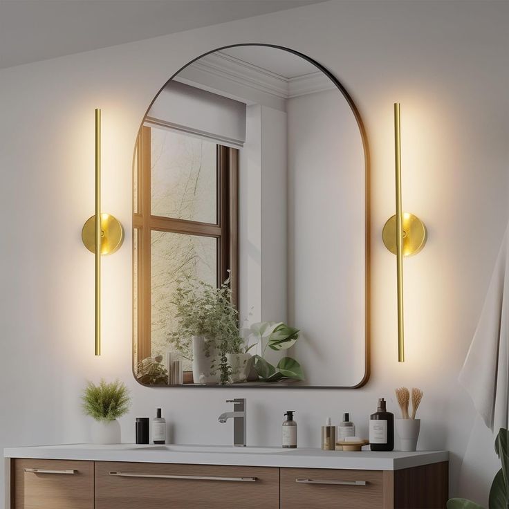 a bathroom with a large mirror and two lights on the wall next to a sink