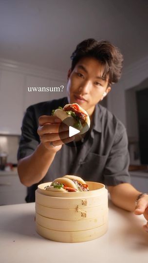 a man holding a sandwich in his hand while sitting at a table