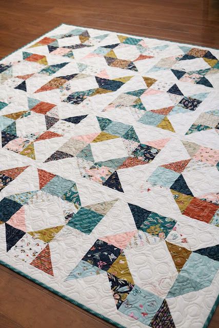 a multicolored quilt is laying on the floor