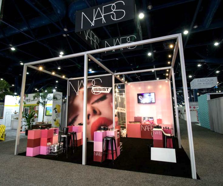 an exhibit booth with pink and white furniture