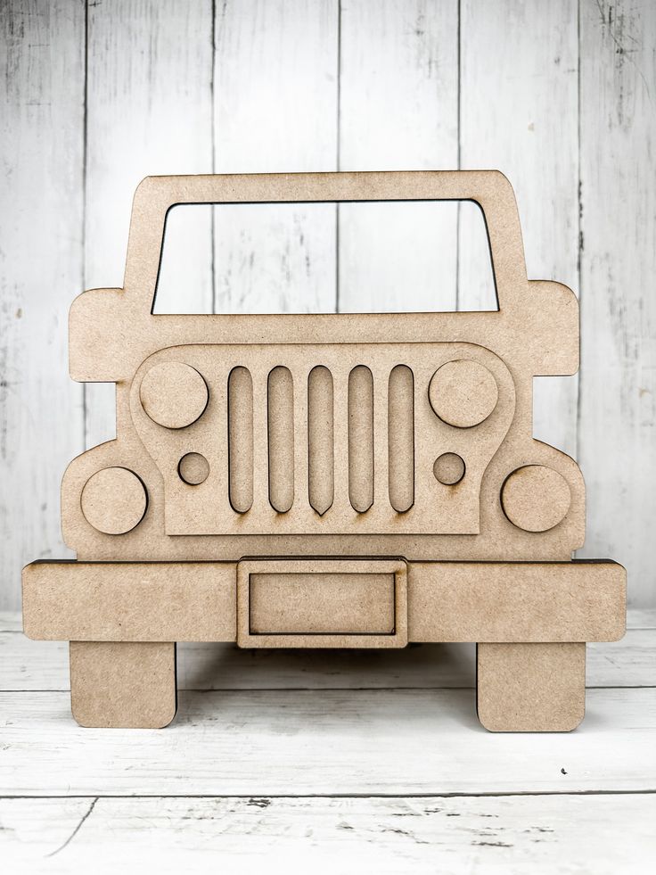 a wooden toy jeep is sitting on a table