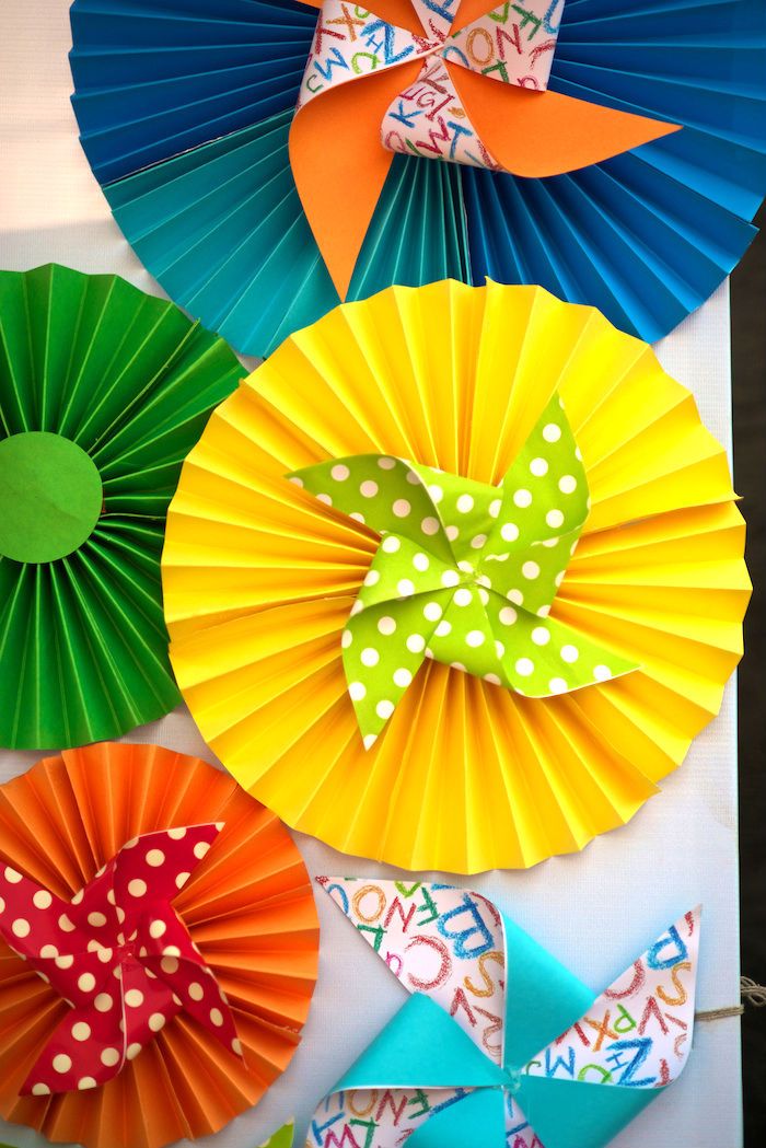 colorful paper fans are arranged on the wall