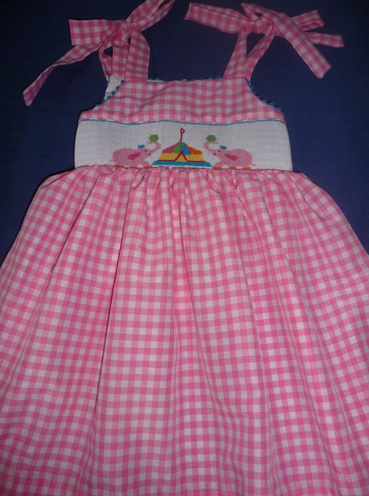 Hand smocked summer dress with pink elephants and circus. Ties at the shoulders and back. This could be a birthday dress. For other sizes allow 3 tweeks Playful Smocked Dress With Smocked Bodice For Summer, Cute Pink Smocked Dress With Smocked Back, Playful Pink Dress With Smocked Back, Playful Summer Smocked Dress, Playful Summer Smocked Dress With Smocked Back, Playful Pink Dress With Smocked Bodice, Playful Pink Smocked Dress With Ruffles, Pink Smocked Dress For Playtime In Summer, Pink Smocked Dress For Summer Playtime