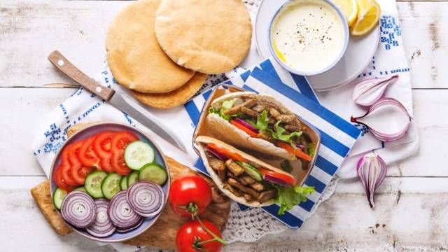 an assortment of food is displayed on a white wooden table with blue and white napkins