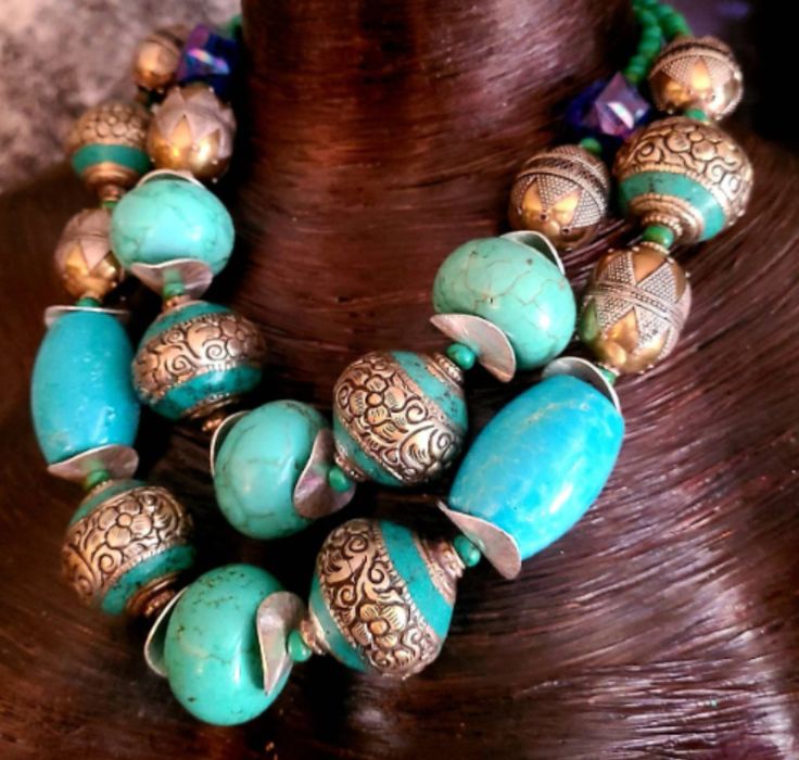 Oversized Neck Candy with an Ethnic Influence for collectors of Socialite Jewelry. I created this Two strand Turquoise Magnesite Jumbo Beaded Statement Necklace from magnesite rondelles/barrels, wavy metal silver spacers, tiny turquoise spacers, Tibetan Repousse, Turkmen Silver and lucite cubes. Adjusting from 18-21", the Bold Chunky Tribal Haute Couture piece closes with silver tone hardware, an xl fancy lobster claw clasp, and a 3" extender chain. A vintage Kuchi Coin hangs from the extender c Artisan Turquoise Necklace For Festivals, Traditional Blue Turquoise Necklace With Large Beads, Traditional Handmade Turquoise Beads, Artisan Turquoise Large Beads, Traditional Turquoise Beads With Natural Stones, Traditional Turquoise Necklace With Round Beads, Traditional Turquoise Genuine Beads, Artisan Large Turquoise Beads, Adjustable Traditional Turquoise Necklace With Large Beads