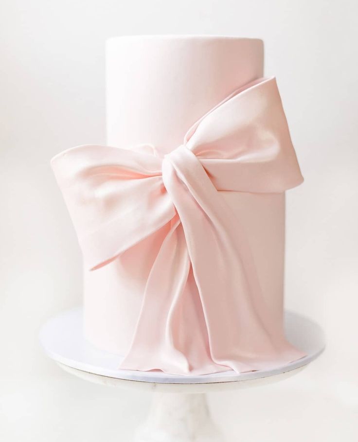 a white cake with a pink bow on top