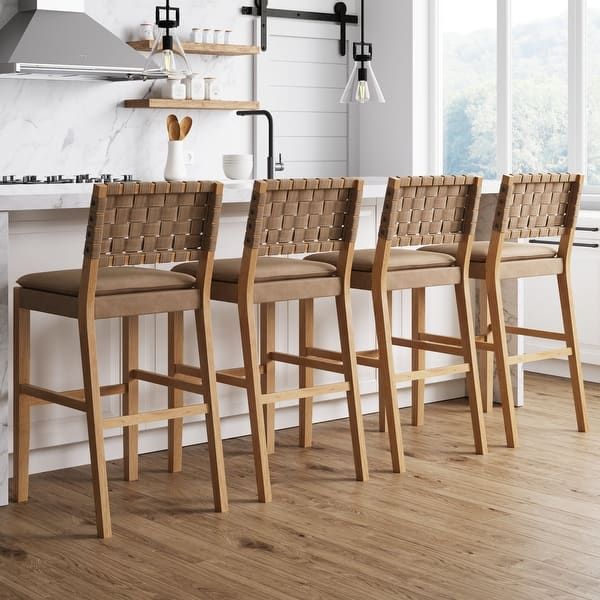 four chairs are lined up in front of the kitchen counter and bar stools with woven seat cushions