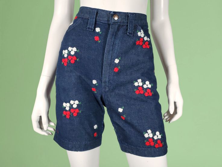 Crewel stitched floral jeans shorts with long legs & a high rise. The denim is a dark wash medium weght cotton twill with playful red & white floral embroidery throughout. There are 2 roomy front pockets & 2 more in back, one with the robust Wrangler patch with the block letter rope logo. And with the help of the vertical darts in back, they also have a curvy feminine fit. There are plenty of chunky mod belt loops, a Scovill metal zip fly, & a branded snap closure. The hems are cut & have an ove Retro Straight Leg Jeans For Spring, Fitted Mid-rise Cotton Shorts, High Waist Relaxed Fit Summer Jeans, Embroidered Straight Leg Summer Bottoms, Summer Embroidered Straight Leg Bottoms, Embroidered Straight Leg Bottoms For Summer, Retro Cotton Jeans For Spring, High Waist Cotton Summer Jeans, High Waist Cotton Jeans For Summer