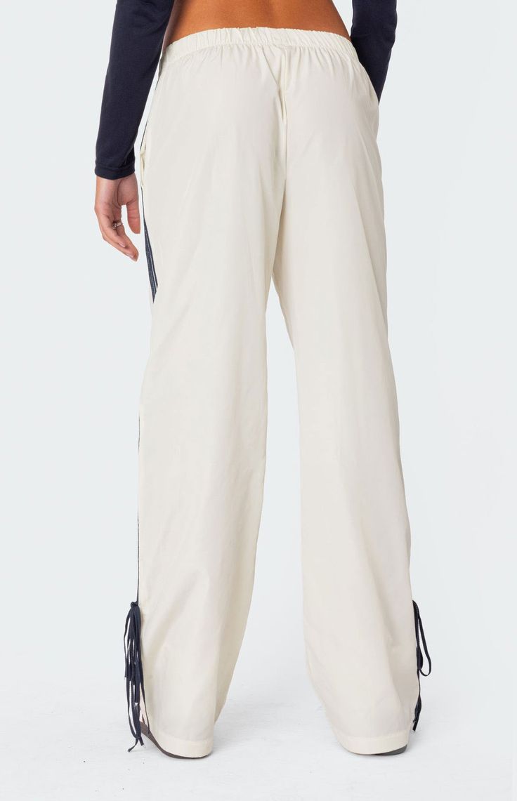 Online only! These track pants offer both style and comfort, making them perfect for a sporty yet fashionable look. They're ideal for any activity, ensuring you feel comfortable and confident throughout your entire day.


	Track pants
	Side stripe detailing
	Ribbon tie ankle detail
	Elastic waist
	Polyester
	Model wears size S
	Model height is 5'7
	Item care: Wash with similar color Visionary Fashion, Track Pants Women, Curve Jeans, Bow Ribbon, Ribbon Tie, Pant Shirt, Side Stripe, Short Rompers, Basic Tees