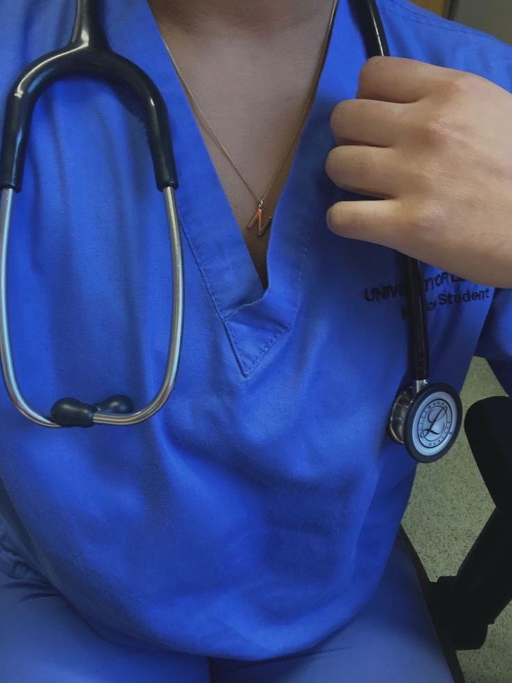 a person in blue scrubs holding a stethoscope