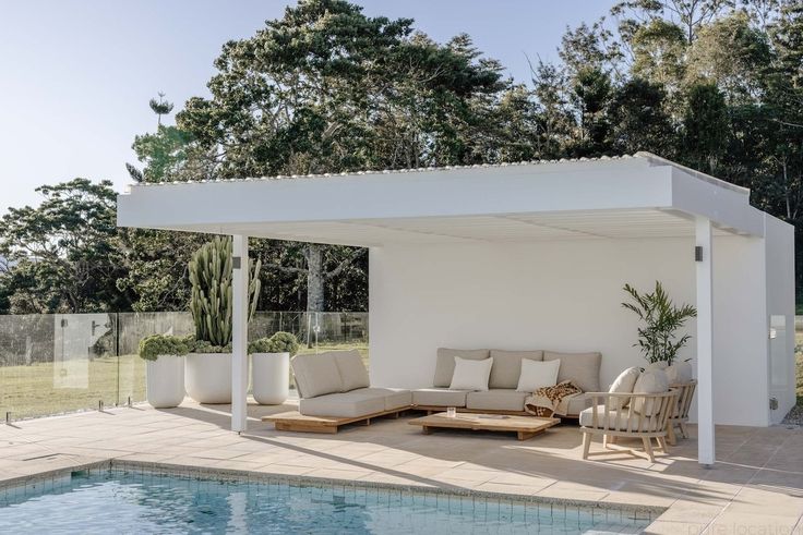 an outdoor living area next to a swimming pool