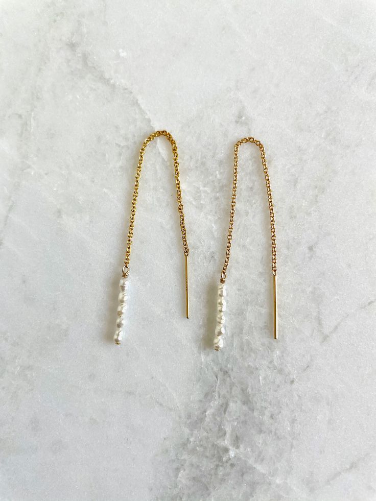 "Super dainty threader earrings with teeny tiny white or peach rice seed pearls hanging from gold filled chain or sterling silver chain. Seed pearls are tiny, 2mm-3mm size.  Earring is 3.5\" tip to tip. So lightweight you can barely feel them. Sold as a pair." Delicate 14k Gold Filled Threader Earrings, Minimalist Pearl Chain 14k Gold Filled Earrings, Minimalist Pearl Chain Earrings In 14k Gold Filled, Minimalist 14k Gold Filled Pearl Chain Earrings, 14k Yellow Gold Filled Threader Earrings With Delicate Chain, Delicate 14k Yellow Gold Filled Threader Earrings, Everyday 14k Gold Filled Pearl Chain Earrings, Delicate 14k Gold Filled Earrings With Pearl Chain, Dainty Long Drop Linear Earrings With Delicate Chain