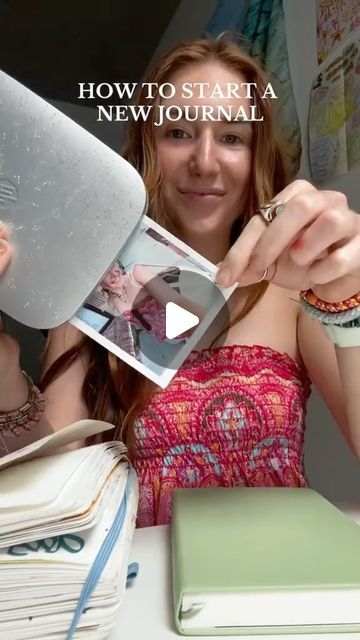 a woman is holding up a new journal