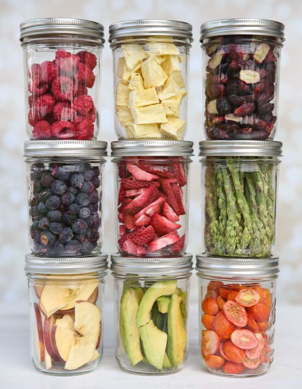 six glass jars filled with different types of fruits and vegetables