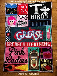 a cross stitched blanket with the words grease, grease and lightening on it