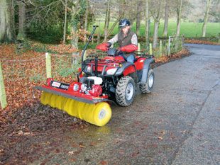 a man riding on the back of a red four - wheeler with a snow plow attached to it