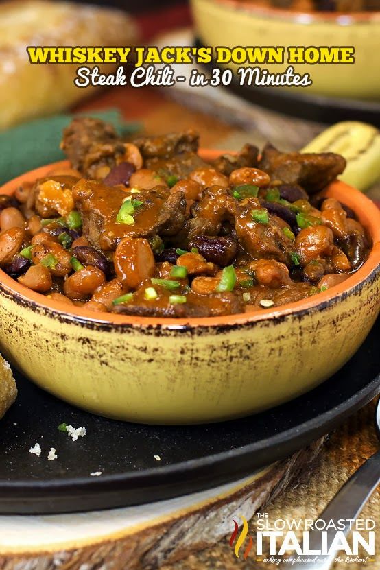 a bowl filled with meat and beans on top of a table