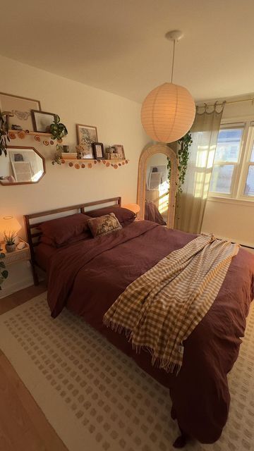 a bedroom with a bed, mirror and plants on the wall