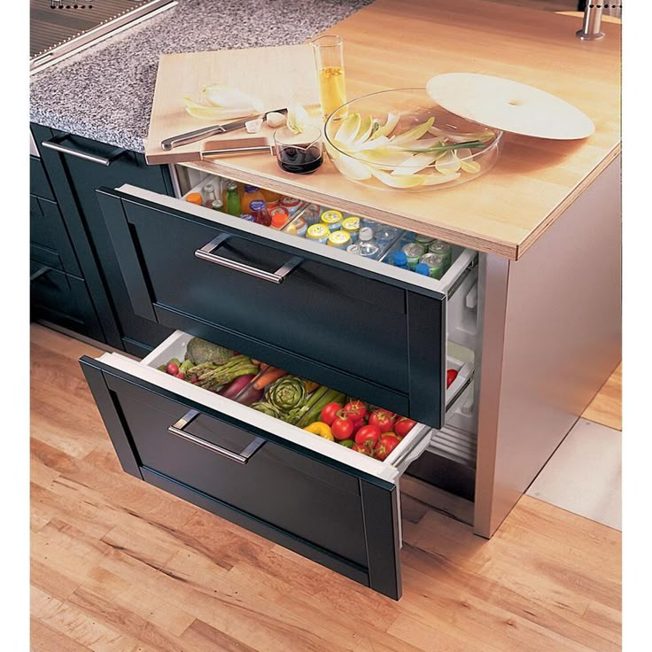 an open refrigerator with food in it sitting on a wooden floor next to a counter