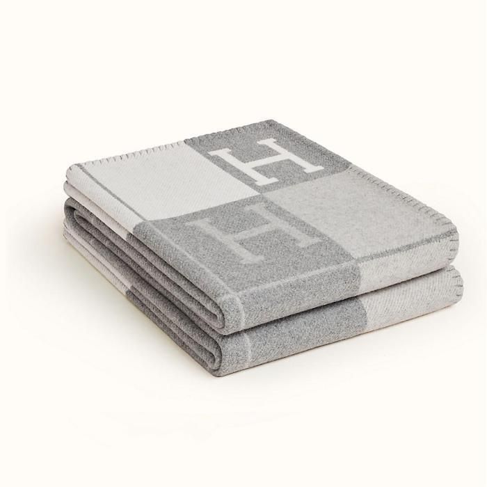 two towels folded on top of each other in front of a white background with the letter h