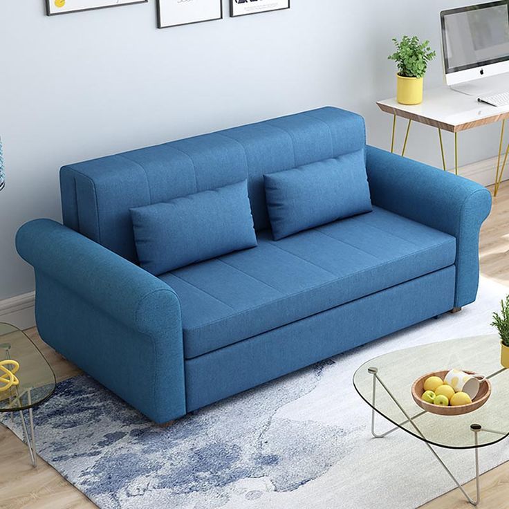 a blue couch sitting on top of a wooden floor