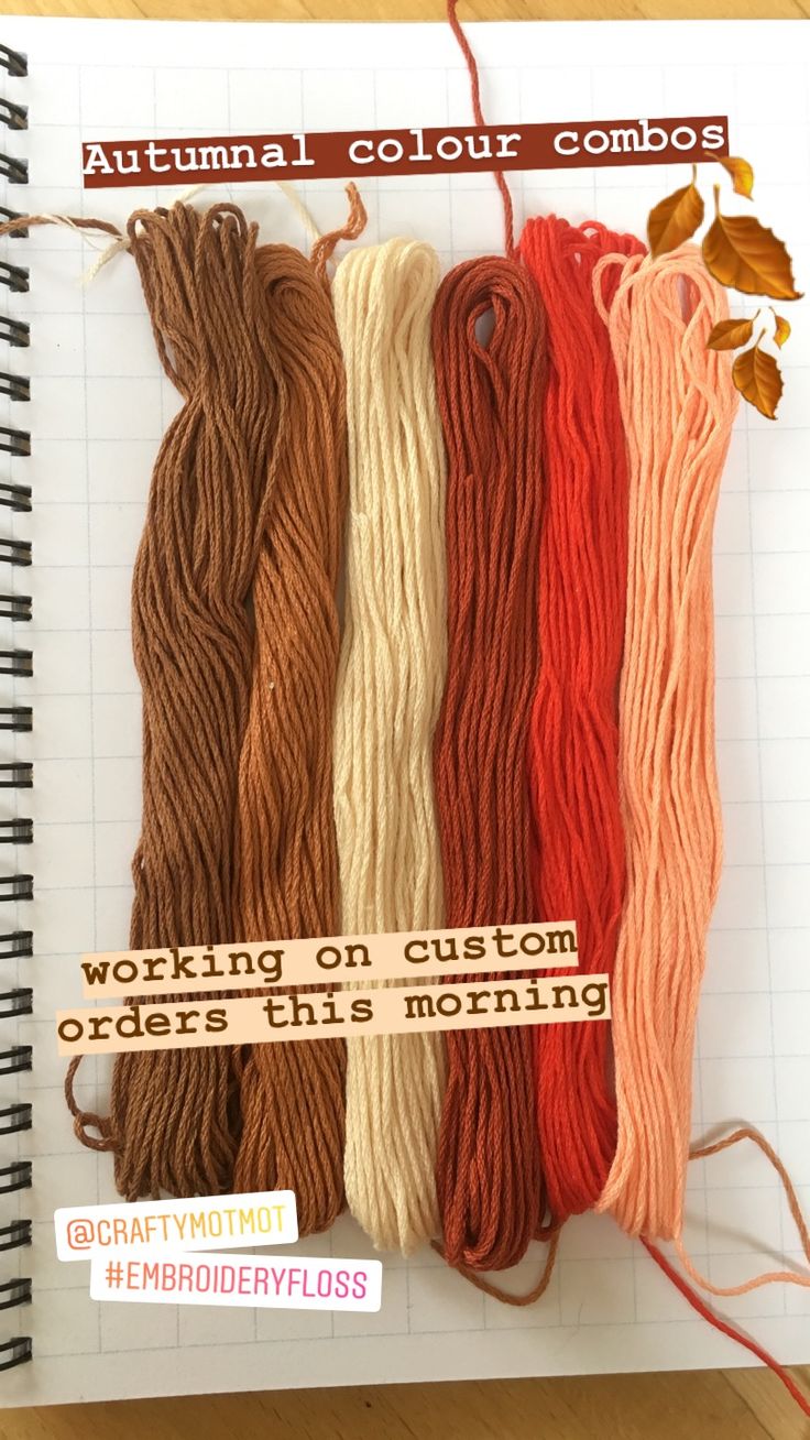 four skeins of yarn sitting next to each other on top of a notebook