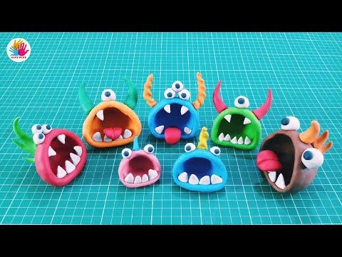 five different colored plastic monsters with their mouths open and eyes wide open on a blue surface