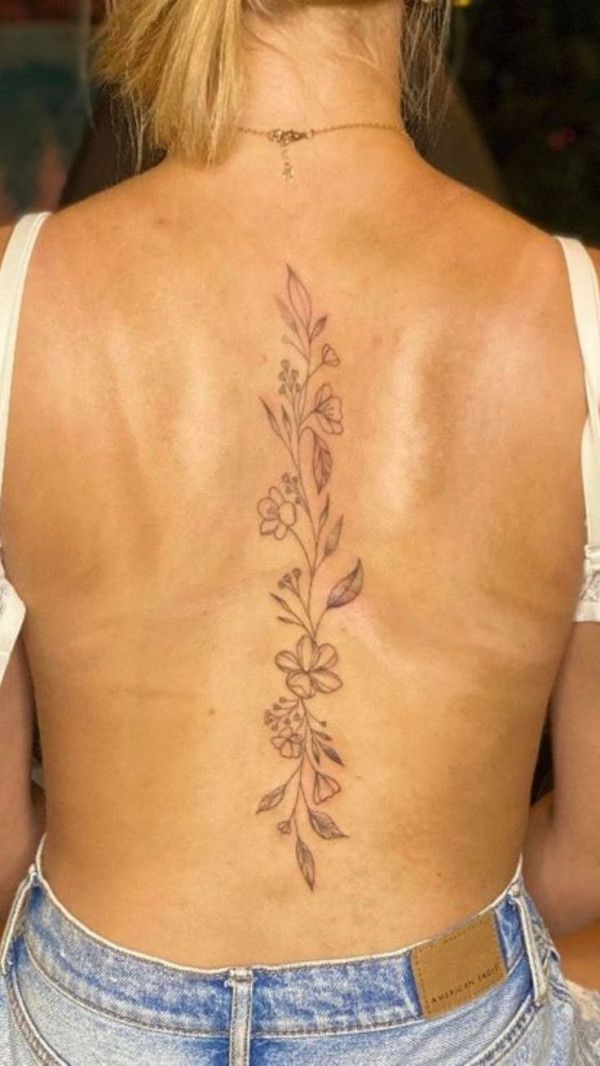 the back of a woman's body with flowers on her upper and lower back