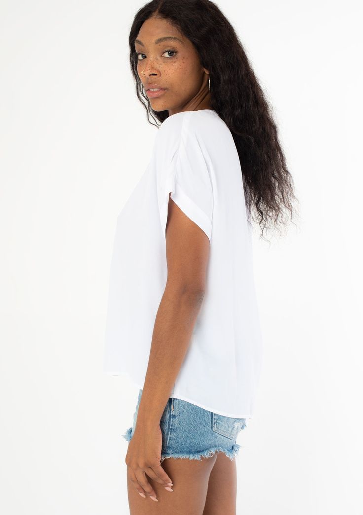 An unbelievably soft and silky hand feel elevates this classic short sleeve top. Featuring a cuffed sleeve, a flattering v-neckline, and a flowy, relaxed fit. Try it loose over jeans for a cool and casual vibe, or tuck it into trousers for a polished look. Silky crepe Relaxed fit V-neckline Short cuffed sleeve Banded collar Split neckline Bohemian top Model is 5'9, wearing a size S.Style: I-13140W-RPL Casual V-neck Blouse With Rolled Sleeves, Relaxed V-neck Blouse For Day Out, Relaxed Fit V-neck Top For Day Out, Effortless V-neck Blouse For Day Out, Relaxed Fit V-neck Blouse For Day Out, Solid V-neck Blouse For Layering, Effortless Short Sleeve Tops For Layering, Relaxed V-neck Top For Day Out, Relaxed Short Sleeve Tops For Layering