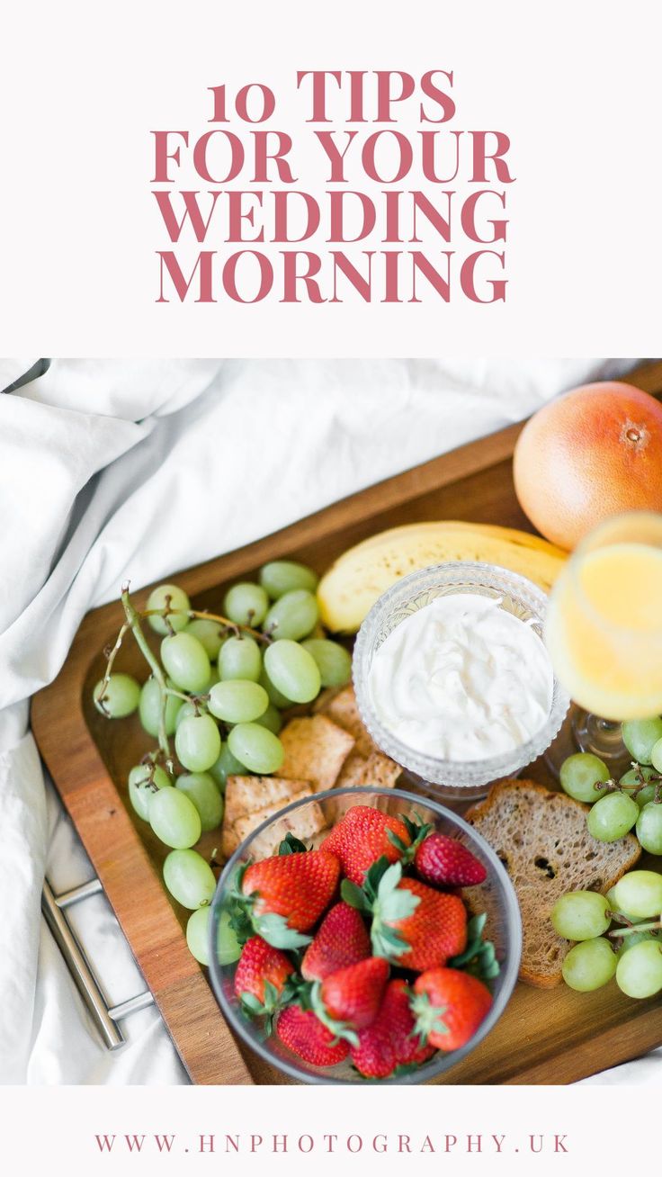 a wooden tray topped with fruit and cheese