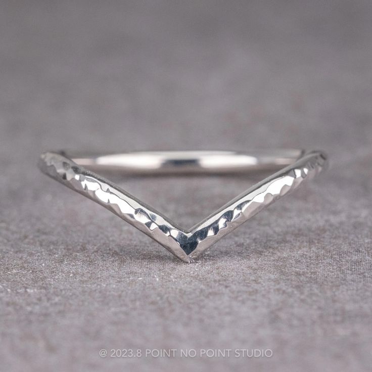 a close up view of a silver ring on a gray surface with the corner cut out