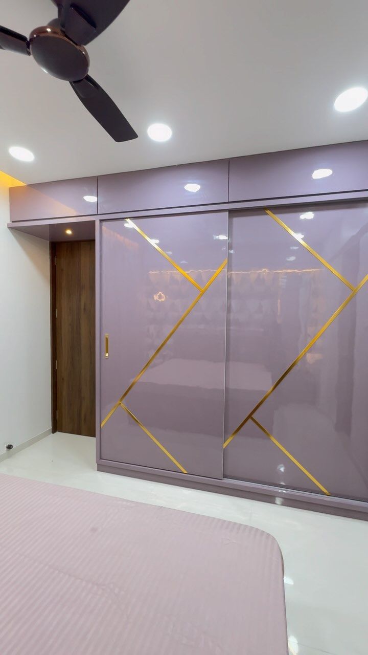 a bedroom with a ceiling fan and sliding glass closet doors in the middle of it