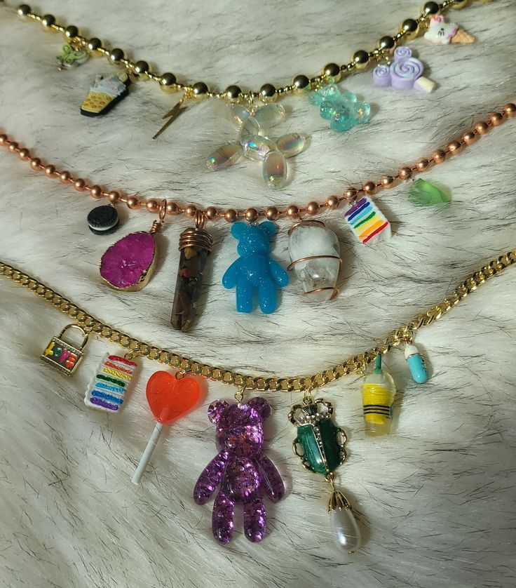 These cute chunky charm necklaces are super adorable and feature Crystal Gemstones on the copper necklace 💜 The copper necklace includes an oreo, Rainbow moonstone, teddy bear gummy, Tiger eye Pendulum, Pink Agate, slice of cake and green freeform jelly. Top necklace has a chunky plastic gold necklace includes some icecream pendants, butterfly, jelly dog and thunder bolt pendants  Bottom necklace  has a gold Cuban Link Chain and features a Victorian beetle pearl pendant, jelly bear, ice-cream, Lollipop, cake, locket and medicine pill All crystals are Sun Cleansed to purify & infused with positive energy. All stones are  Ethically Sourced Gemstones and ship from beautiful Pennsylvania. Crystal Chunk Necklace, Chickasaw Necklace, Trendy Handmade Charm Necklaces As Gift, Fun Charm Necklaces For Gifts, Cute Dangle Charm Necklaces For Jewelry Making, Cute Nickel-free Metal Charm Necklaces, Cute Nickel-free Metal Charm Necklace, Cute Metal Charm Necklace Nickel Free, Cute Metal Pendant Charm Necklace