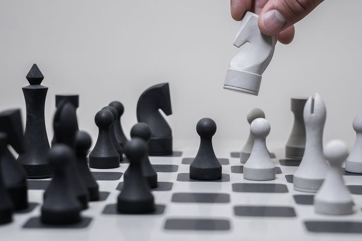 a person is playing chess with white and black pieces