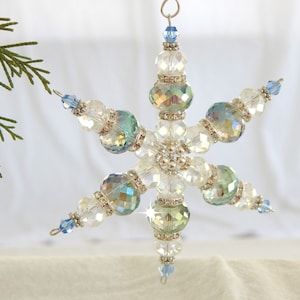 a snowflake ornament hanging from a christmas tree