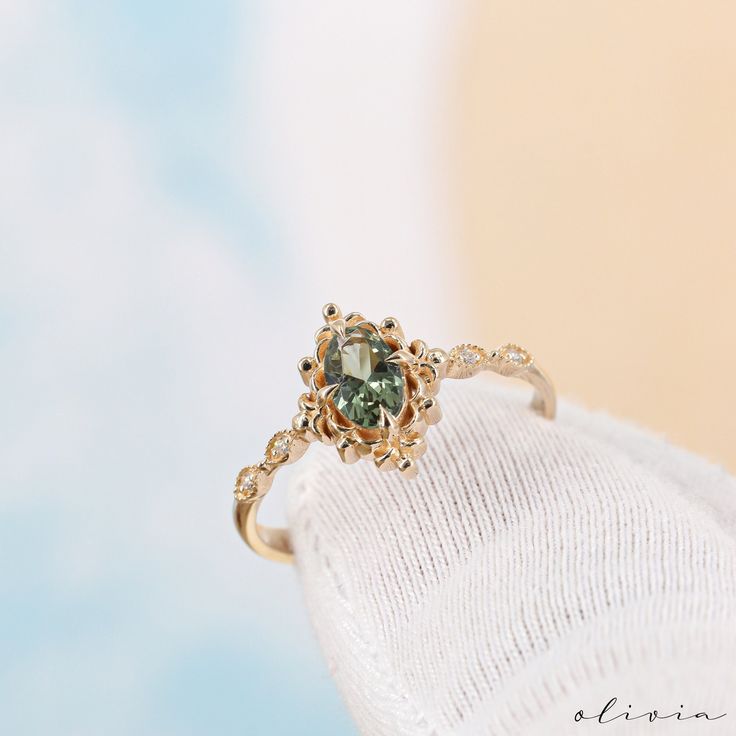 a close up of a ring with a green stone on it's center piece