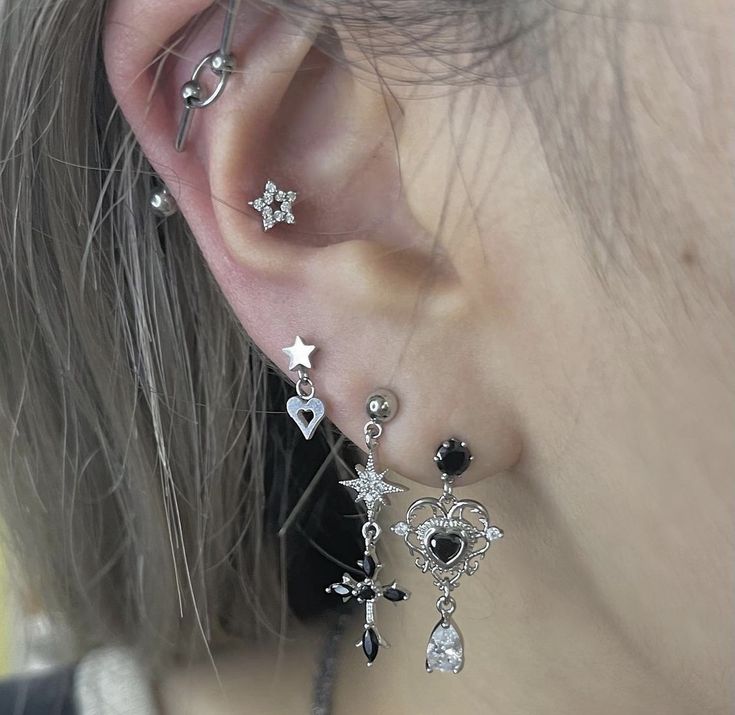 a close up of a person with ear piercings on their ears and wearing jewelry