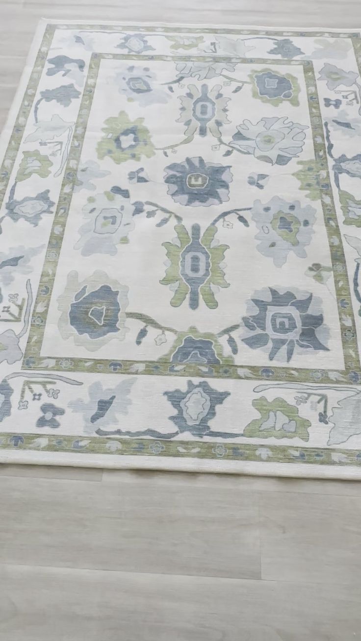 a white rug with blue and green flowers on it