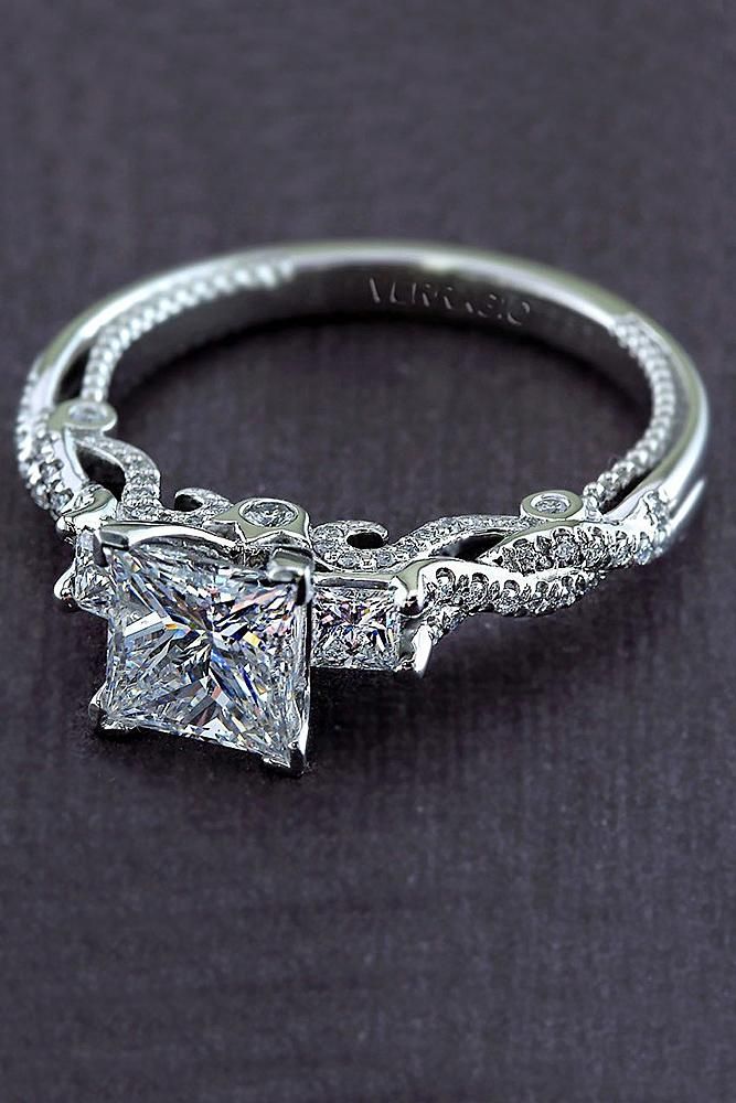 a princess cut diamond engagement ring on a black background