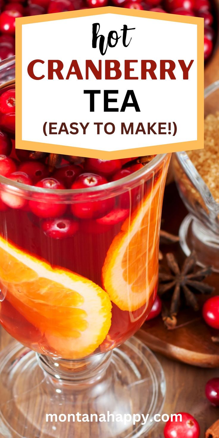 cranberry tea in a glass cup with orange slices and cinnamon on the side