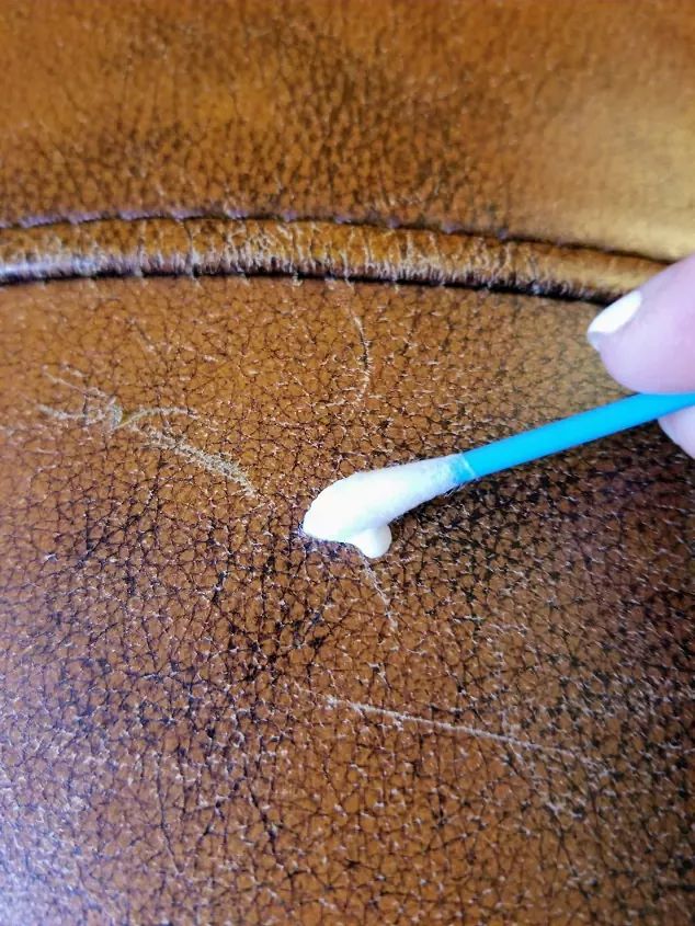 someone is using a toothbrush to brush their teeth on the leather seat of a chair