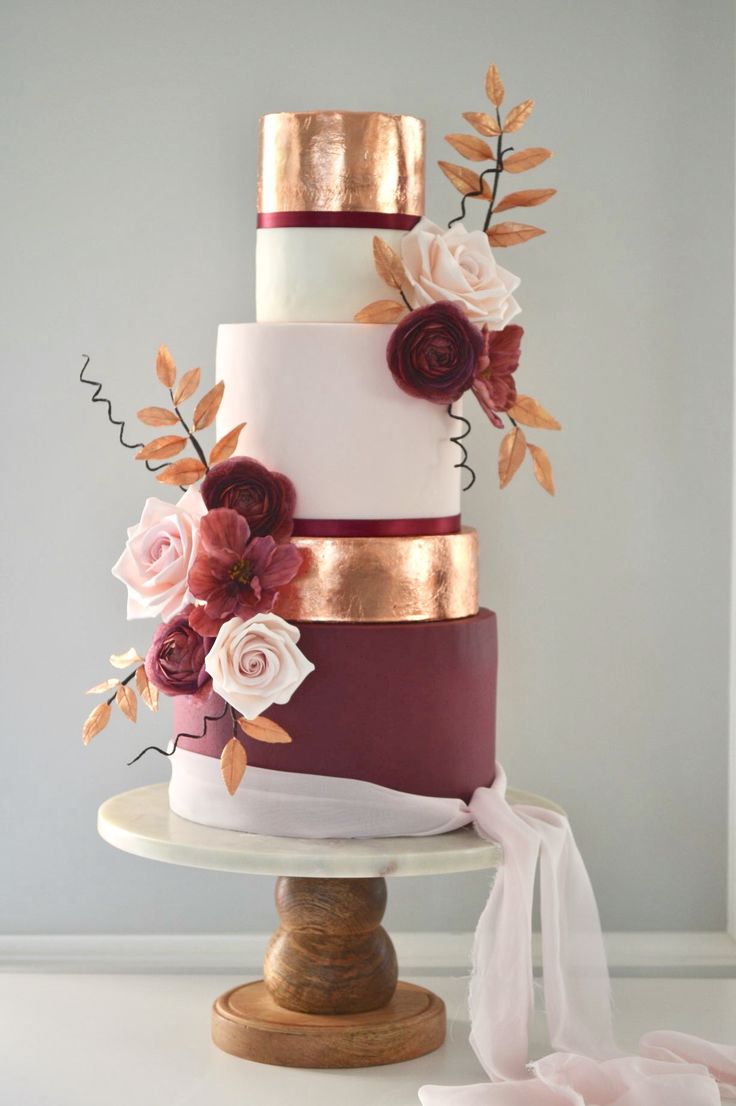 a three tiered wedding cake with flowers on top