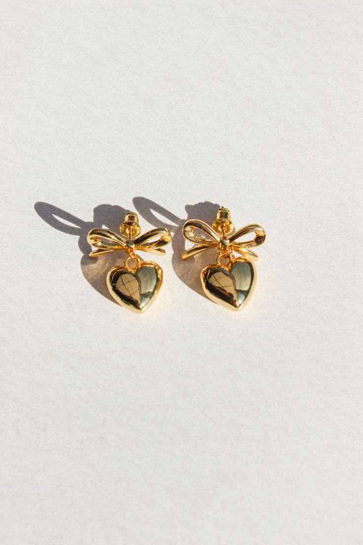 PRODUCT DESCRIPTION Fall in love with our Sweetheart Earrings, featuring an adorable bow and heart design. These charming earrings effortlessly blend whimsy and romance, making them the perfect accessory for any occasion. Gold Statement Earrings Water Resistant 18k Gold-plated on Hight Quality Brass Size: 2.4cm in height Read our full Jewellery Care Guide here Read our Sizing Guide here Bow Drop Earrings For Anniversary, Anniversary Bow Drop Earrings, Cute Heart Earrings For Valentine's Day Wedding, Cute Heart Earrings For Wedding On Valentine's Day, Dainty Earrings For Valentine's Day Party, Dainty Valentine's Day Party Earrings, Heart-shaped Earrings With Bow For Gift, Cute Wedding Earrings For Valentine's Day, Feminine Dangle Heart Earrings For Valentine's Day