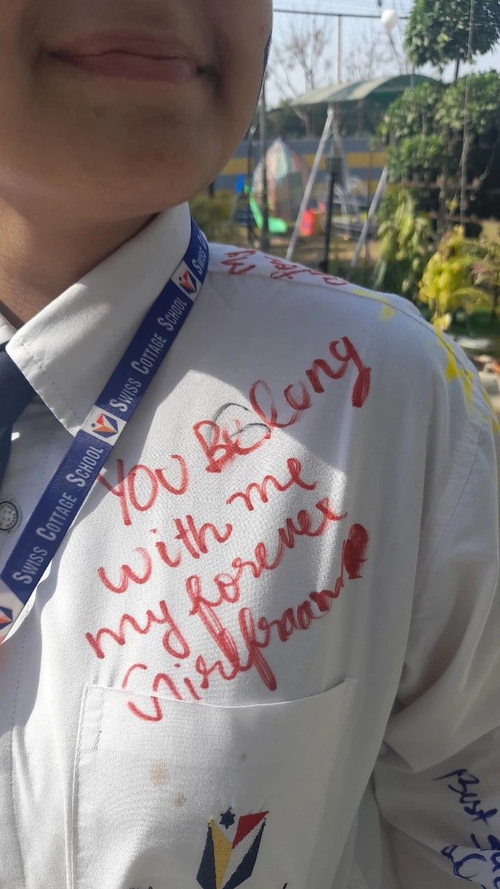 a close up of a person wearing a shirt and tie with writing on the chest