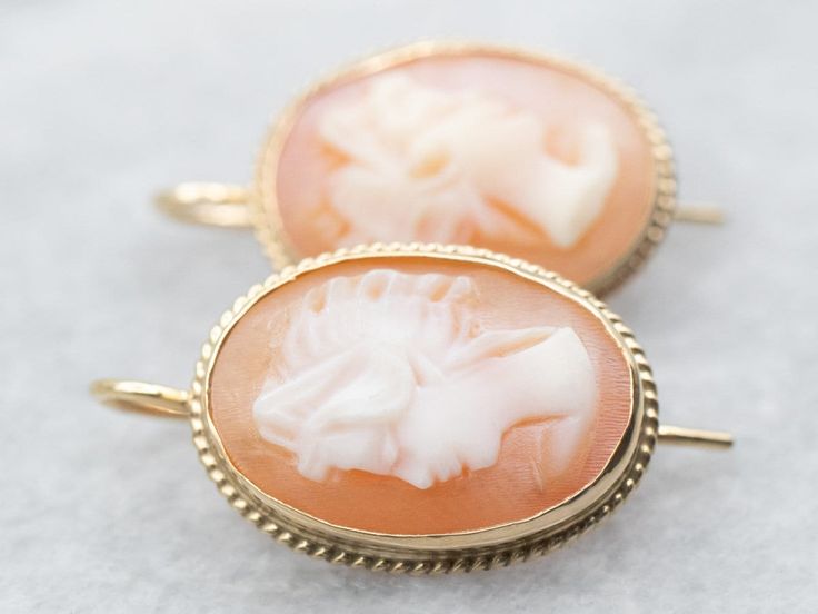 These Mid-century cameo drop earrings are simply lovely!  The carving is exquisite, the colors of the natural shell are perfect, and the mountings are perfectly polished, with a versatile twisting accent. Metal: 14K Yellow Gold Gem: 2 Shell Cameo Gem Measurements: 10.3 x 14.4 mm, Oval Measurements: 12 x 20 SKU #: A36700 Each piece has been identified and graded by a Graduate Gemologist who has been certified by the Gemological Institute of America (GIA). We have six brick-and-mortar storefronts in Maine, Massachusetts, and New Hampshire and have been in business for over 25 years! Please visit our Shop's About Page or our website for more information about our jewelry. For questions about diamond grading, we recommend the Gemological Institute of America (GIA) who were the founders of the Carved Yellow Gold Earrings For Formal Occasions, Formal Carved Yellow Gold Earrings, Elegant Carved Yellow Gold Earrings, Classic Intaglio Earrings As A Gift, Formal Carved Earrings, Classic Cameo Earrings For Wedding, Antique Formal Earrings, Cameo Drop Earrings For Wedding, Cameo Drop Earrings For Formal Occasions